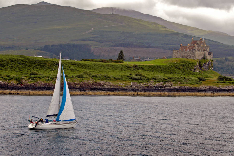 A yacht sailing in the Sound of Mull by Duart Castle on the Isle of Mull, Inner Hebrides