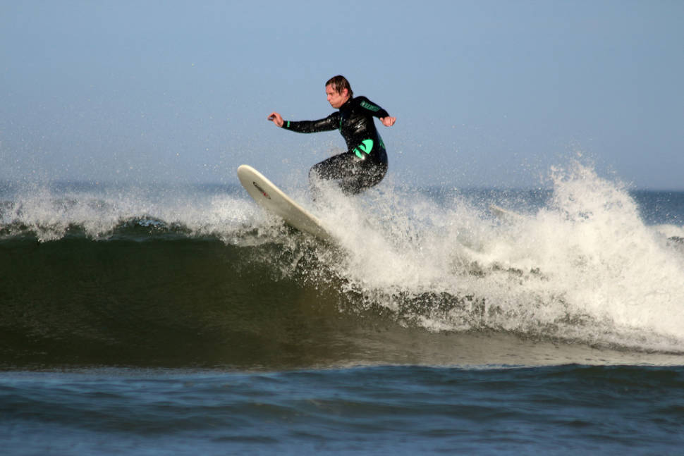 Surfer having fun on the waves at Pease Bay East Lothian Scotland