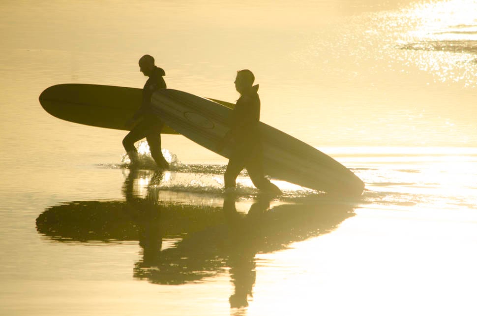 Surfers returning from a hard day's sport at Belhaven Bay, East Lothian