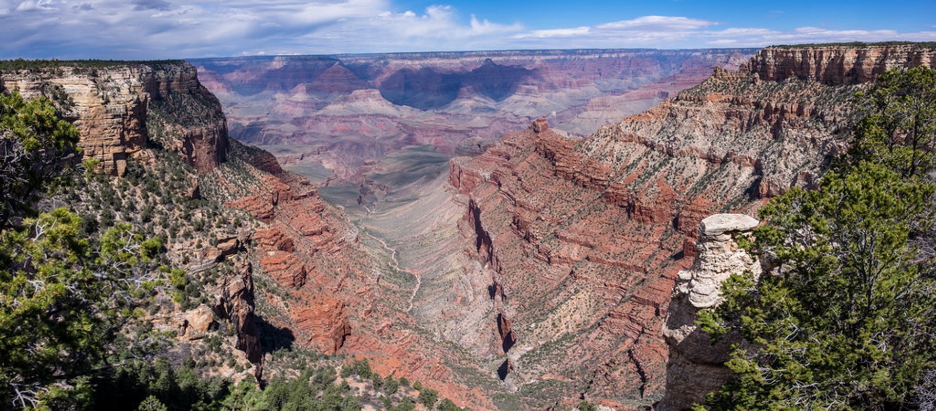 Picture of a hiker standing along a red-rock edge of the Grand Canyon